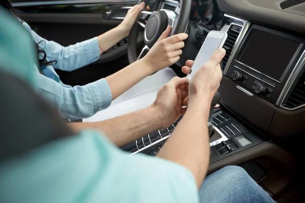 Homem feliz e mulher com o smartphone dirigindo no carro — Fotografia de Stock