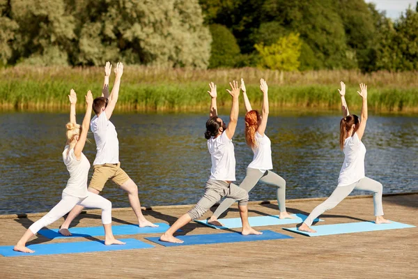 Groep mensen die buiten yoga oefeningen doen — Stockfoto