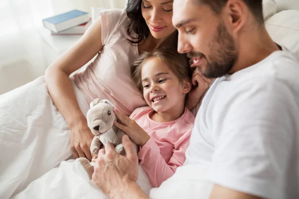 Oyuncak ve yatakta evde ailesi ile mutlu çocuk — Stok fotoğraf