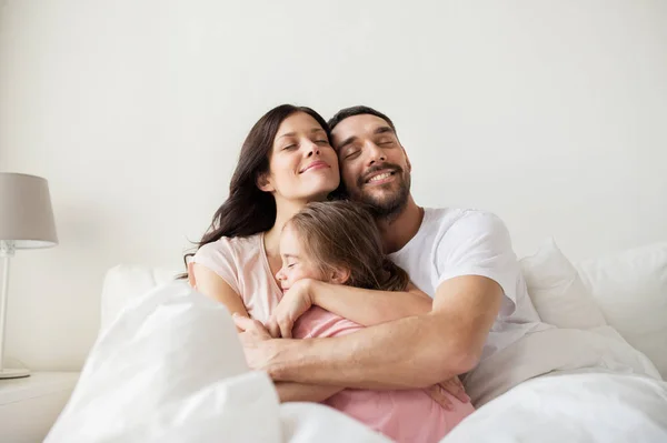 Šťastná rodina objímání v posteli doma — Stock fotografie