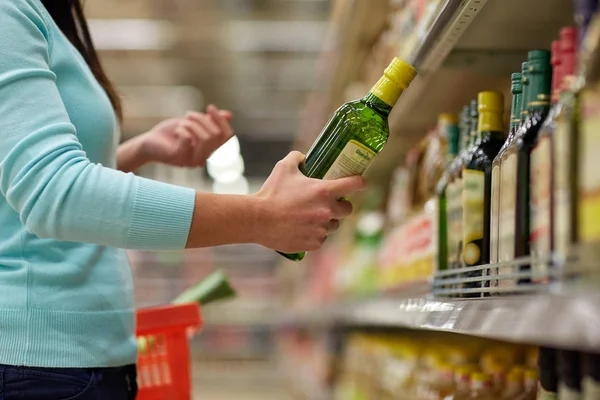Kvinna att köpa olivolja på snabbköpet eller livsmedelsbutiker — Stockfoto