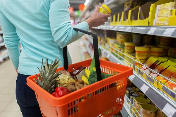 食糧のバスケットと、食料品店で瓶を持つ女性 — ストック写真