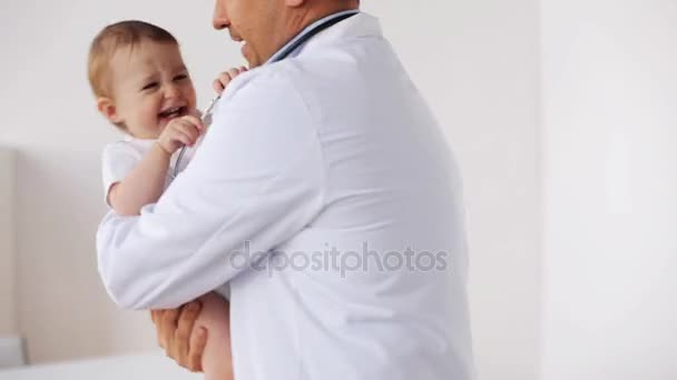 Glücklicher Arzt oder Kinderarzt mit Baby in der Klinik — Stockvideo