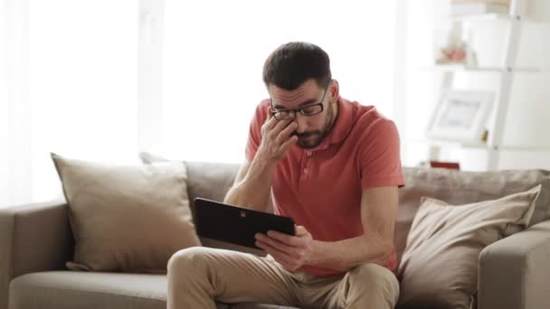 Mannen med TabletPC trött från glasögon hemma — Stockvideo