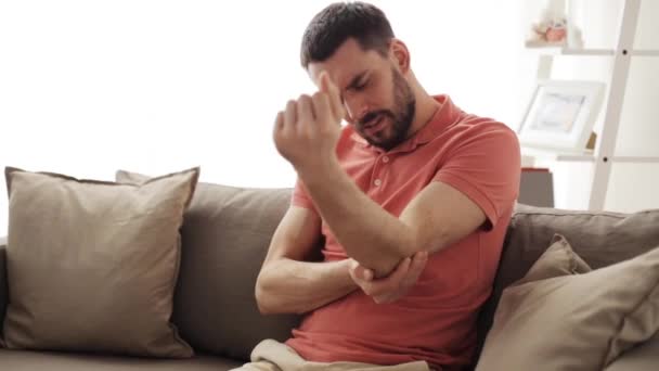 Olycklig man lider av smärta i hand hemma — Stockvideo