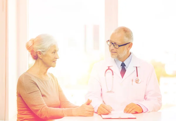 Sonriente mujer mayor y reunión de médico — Foto de Stock