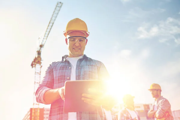 Construtor em hardhat com tablet pc na construção — Fotografia de Stock