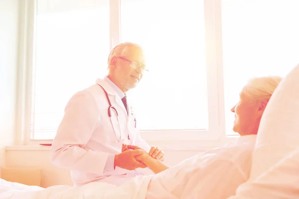 Medico che controlla il polso della donna anziana in ospedale — Foto Stock