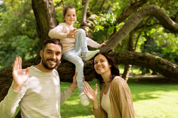 Familia feliz en el parque de verano saludando manos —  Fotos de Stock