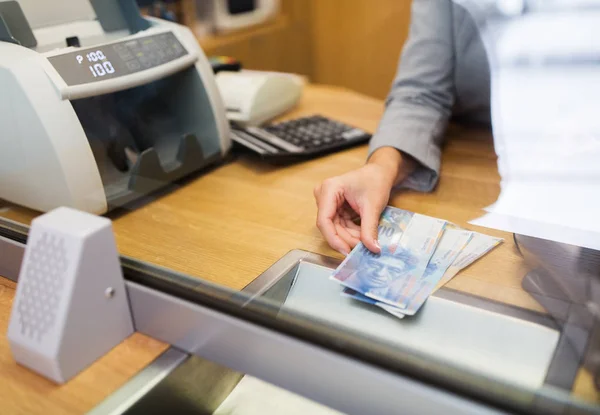 Verkäuferin mit Schweizer Franken Bargeld im Bankbüro — Stockfoto