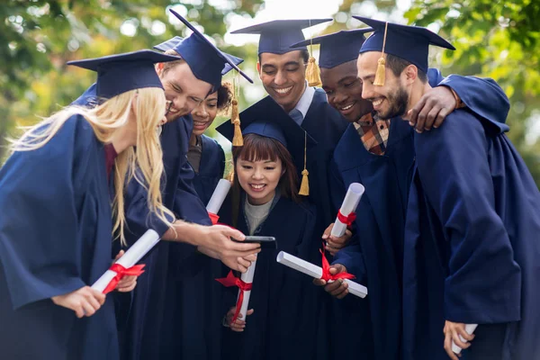 Studentów lub dyplom licencjacki z dyplomami i smartphone — Zdjęcie stockowe