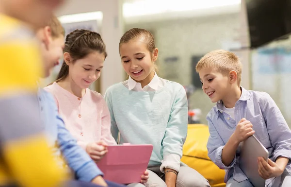 Groep gelukkige kinderen met tablet pc op school — Stockfoto