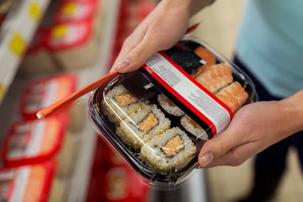 Mâini cu pachet de sushi la cumpărături sau supermarket — Fotografie, imagine de stoc