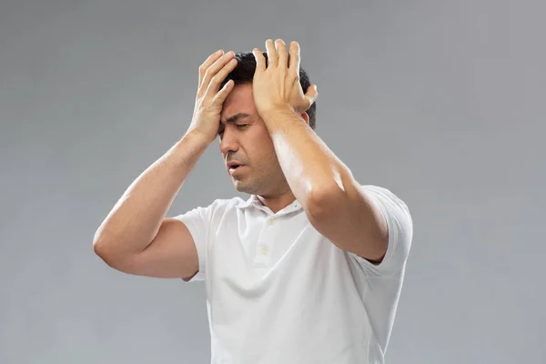 Несчастный человек страдает от головной боли — стоковое фото