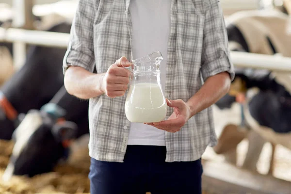Perto do homem ou do agricultor com leite na exploração leiteira — Fotografia de Stock