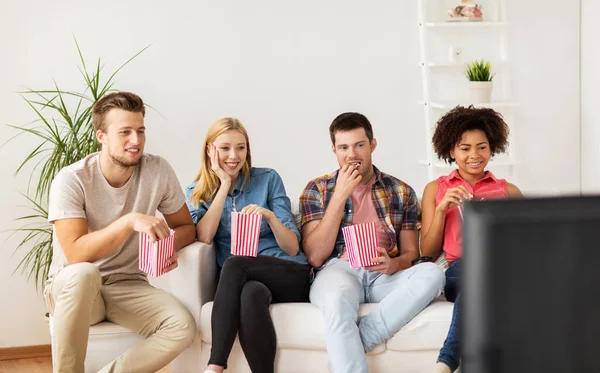 Amigos felices con palomitas de maíz viendo la televisión en casa —  Fotos de Stock