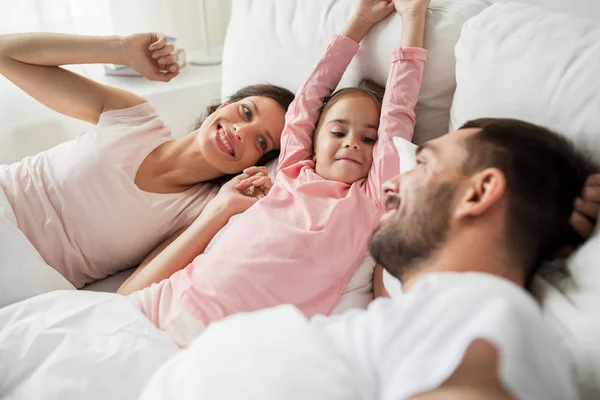 Szczęśliwa rodzina budzi się w łóżku w domu — Zdjęcie stockowe