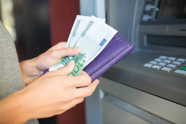 Närbild på hand att ta ut pengar på bankomat — Stockfoto