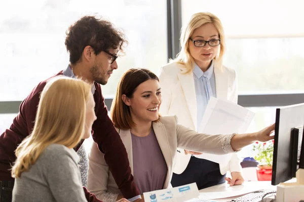 Lykkelig kreativ gruppe med datamaskin i embetet – stockfoto