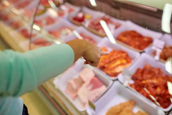 Kunden hand pekar på kött på livsmedelsbutiker stall — Stockfoto