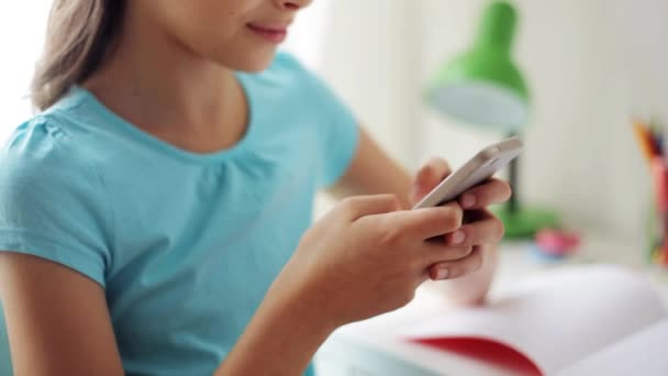 Chica sonriente mensajes de texto en el teléfono inteligente en casa — Vídeos de Stock