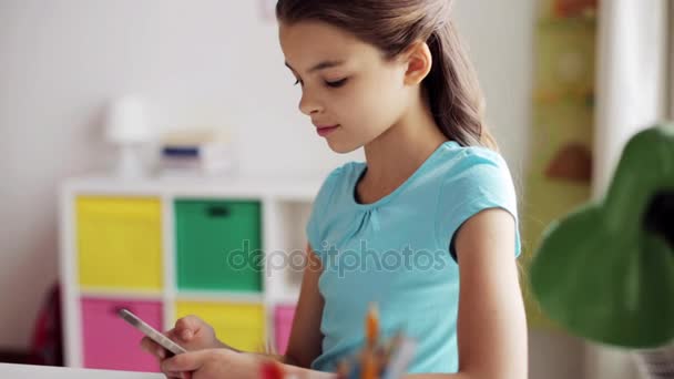 Menina sorrindo mensagens de texto no smartphone em casa — Vídeo de Stock