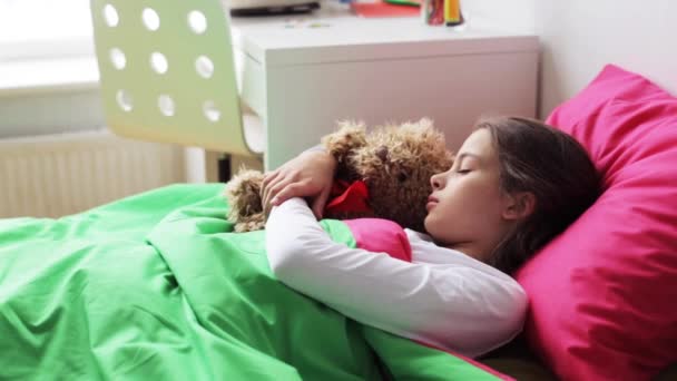 Маленькая девочка с плюшевым мишкой спит дома — стоковое видео