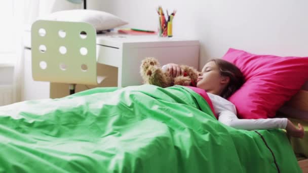 Маленькая девочка с плюшевым мишкой спит дома — стоковое видео