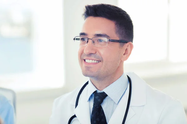 Médico varón sonriente en bata blanca y gafas graduadas —  Fotos de Stock