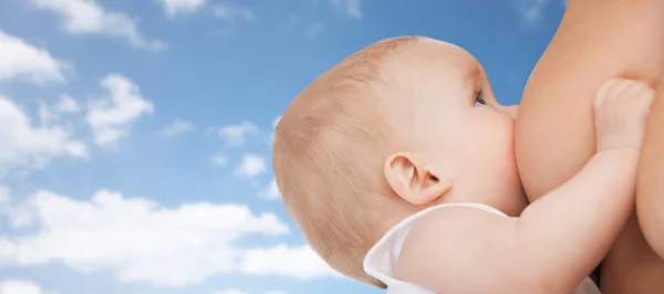 Primo piano dell'allattamento al seno del bambino sopra il cielo blu — Foto Stock