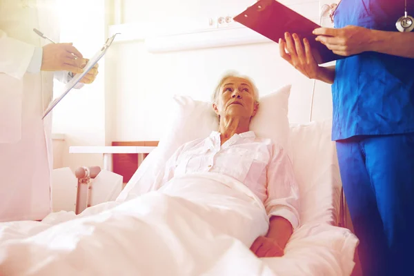 Arzt und Krankenschwester besuchen Seniorin im Krankenhaus — Stockfoto