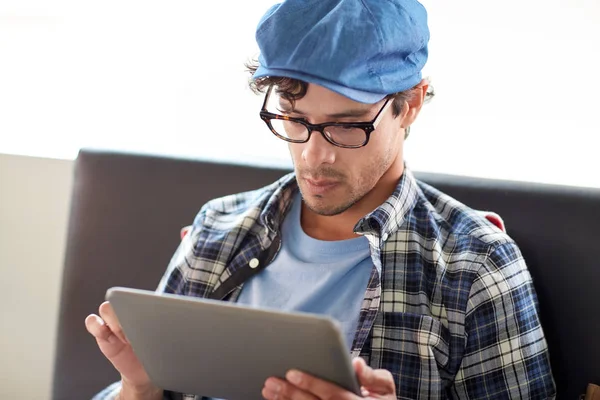 Man met tablet pc zitten aan Cafe tafel — Stockfoto