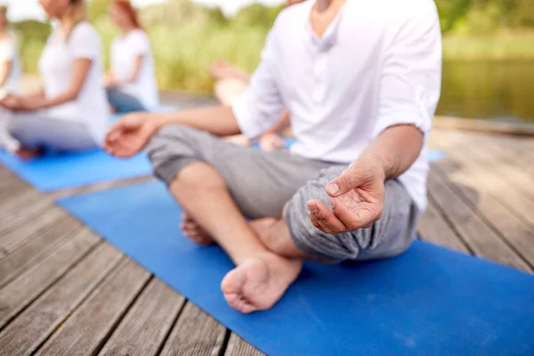 Close up of people making yoga exercises outdoors — Stock Photo, Image
