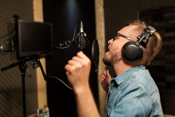 Man met hoofdtelefoon zingen bij opnamestudio — Stockfoto