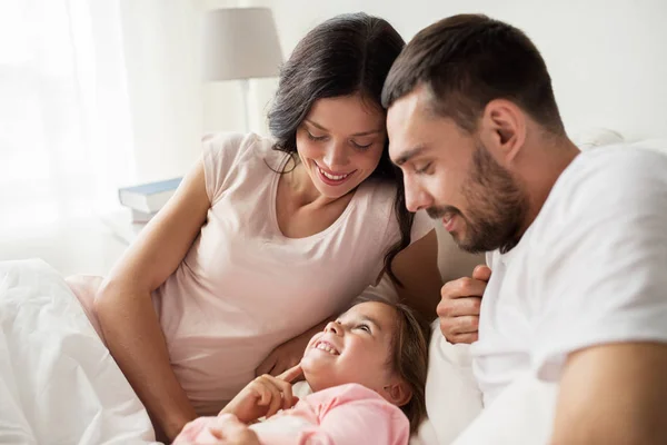 Gelukkige familie in bed thuis — Stockfoto