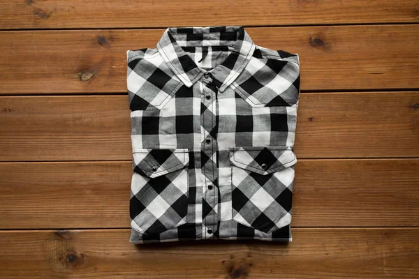 Checkered shirt on wooden background — Stock Photo, Image