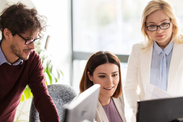 Lykkelig kreativ gruppe med datamaskin i embetet – stockfoto