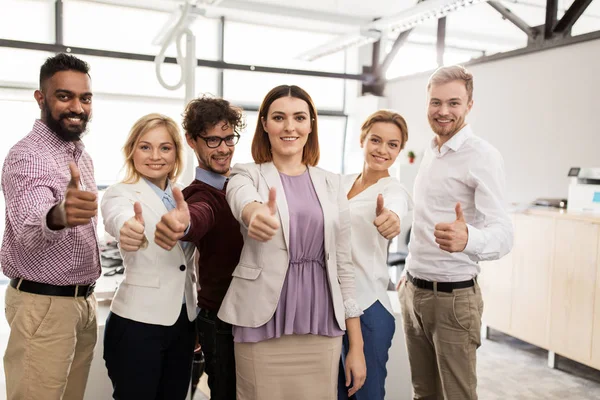 Glad affärsteam visar tummen upp på kontoret — Stockfoto