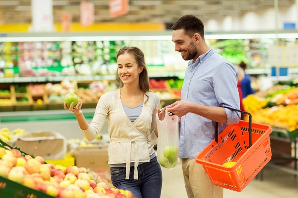 Casal feliz comprando maçãs no supermercado — Fotografia de Stock