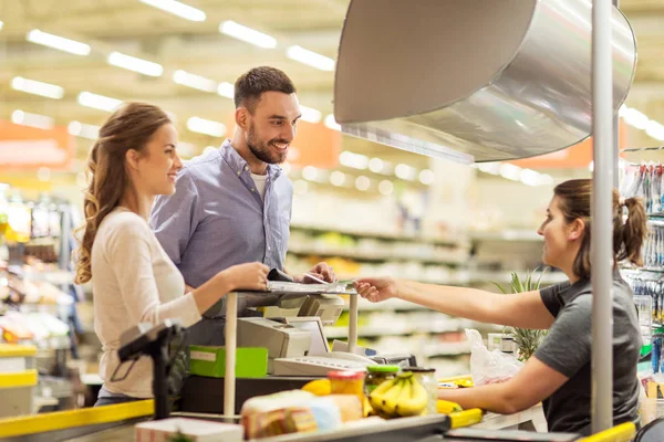 Casal comprando alimentos na loja de mercearia caixa registradora — Fotografia de Stock