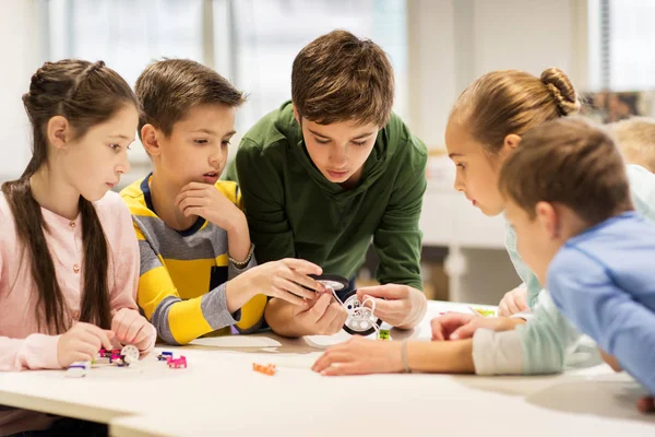 Gelukkige kinderen bouwen robots op robotica school — Stockfoto