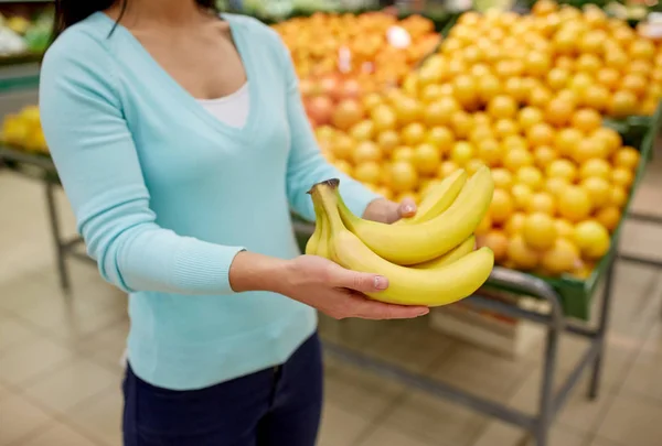 Woman with bananas at grocery store — Stock Photo, Image