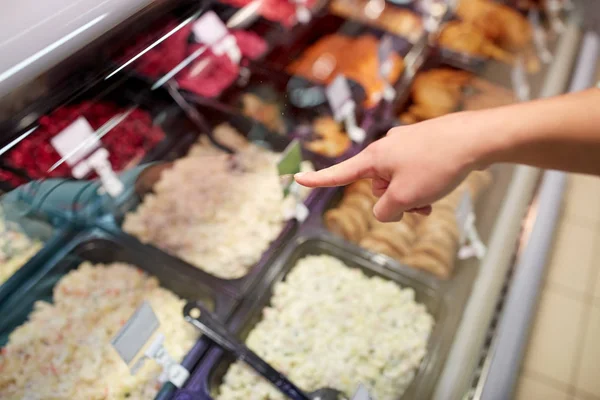 Mano del cliente apuntando a ensaladas en el puesto de comestibles —  Fotos de Stock