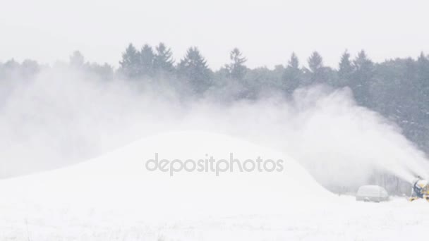 Снежный пистолет делает холм на открытом воздухе зимой — стоковое видео