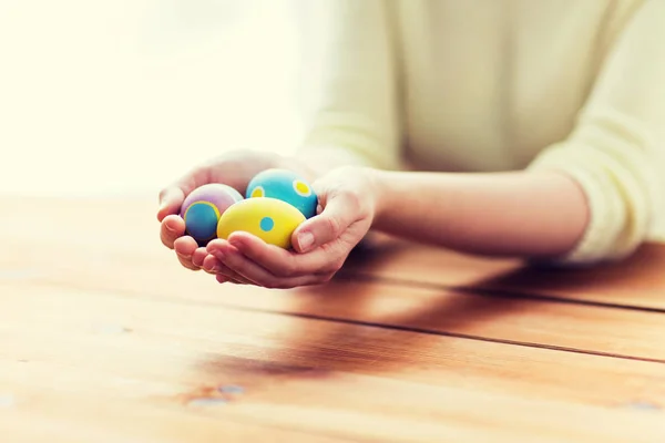 Primer plano de las manos de la mujer con huevos de Pascua de colores — Foto de Stock