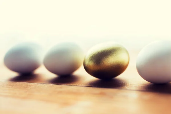 Close up of golden and white easter eggs on wood — Stock Photo, Image