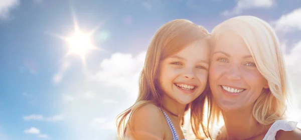 Šťastná matka a dítě dívka nad slunce v modré obloze — Stock fotografie