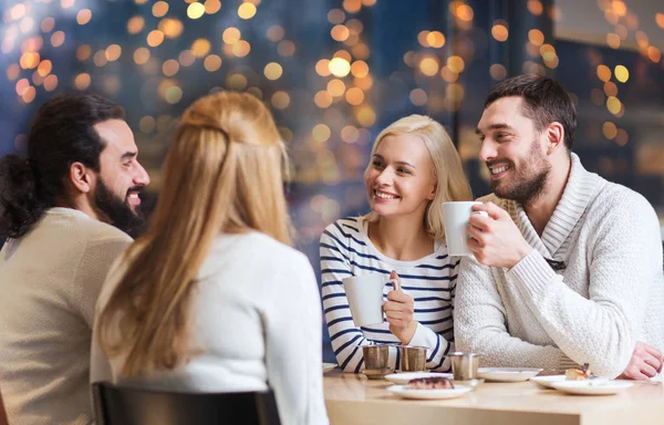 Счастливые друзья пьют чай в кафе — стоковое фото