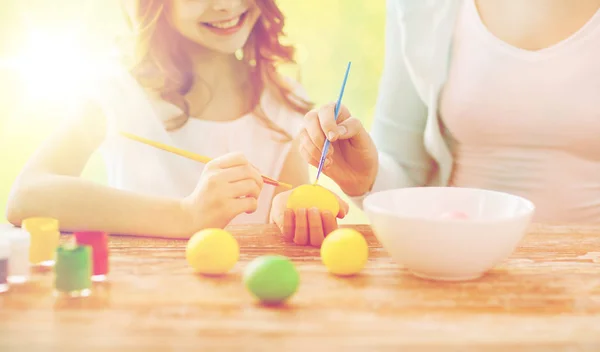 Close up of family coloring easter eggs — Stock Photo, Image