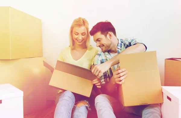 Улыбающаяся пара с большим количеством коробок, переезжающих в новый дом — стоковое фото